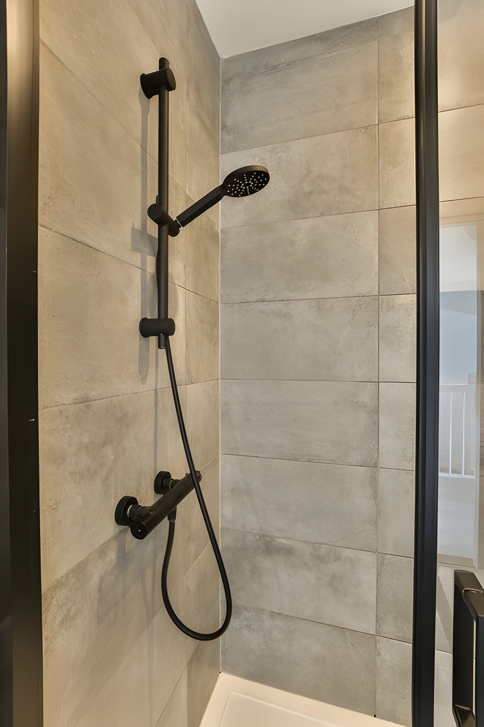 Carrelage Moderne Gris pour une Douche Élégante Transformez votre salle de bain avec un carrelage gris moderne qui apporte une touche sophistiquée et contemporaine à votre espace de douche.